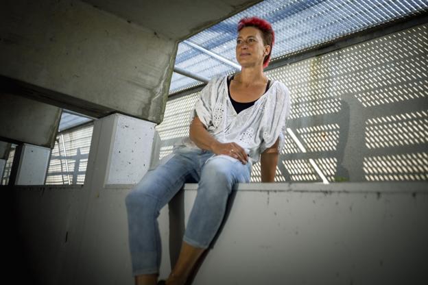 Inge Marie Mørch sidder på en mur og kigger ud